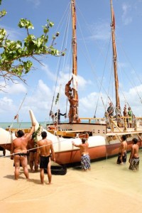 The Hokulea crew ties a khata from His Holiness the 14th Dalai Lama to the ship mast