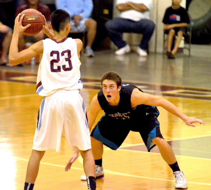 King Kekaulike's Chase Iwata-Bartelme eyes Baldwin's Matthew Demichele during second-half action Tuesday at Baldwin gym. Photo by Rodney S. Yap.