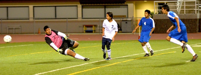 Kamehameha Maui's Daniel Quenga (7) scores the first of his two goals Tuesday night against Maui High. Saber goalkeeper Pani Kapisi stretches out to try and deflect Quenga's shot attempt. Photo by Rodney S. Yap.