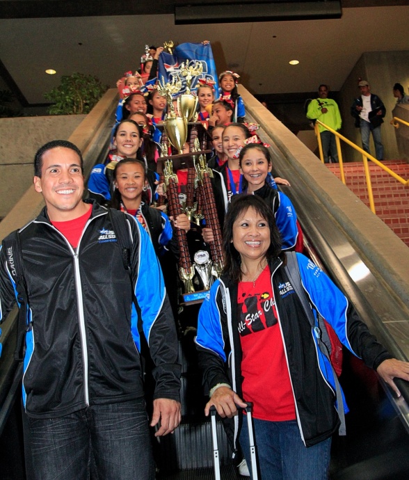 Hawaii All-Star Cheerleaders head coach Kealii Molina (left) and assistant coach Jo-Ann Yap lead the championship parade down the escalator the Kahului Airport baggage claim Monday, March 25. Photo by Ben Juan.