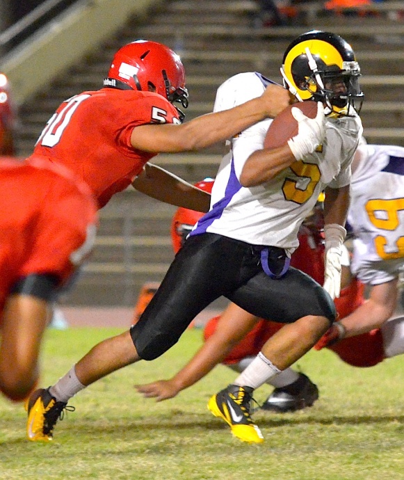 Lahainaluna's Hercules Mata'afa gets a paw on Mt. Douglas running back Marcus Davis. Photo by Rodney S. Yap.