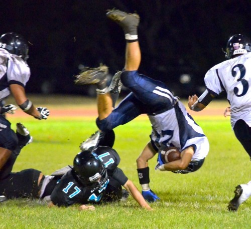 King Kekaulike kicker/punter Micah McDonald (17) upends Kamehameha Maui returner Colton Cabanas in the second half Friday. Photo by Rodney S. Yap.