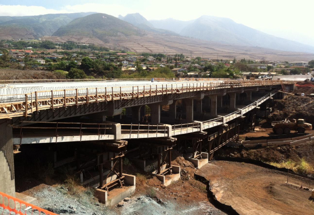 The new bridge, seen above under construction, utilizes an inverted tier arch design, which places arched support beams below the road surface rather than above. This design was selected to minimize obstructions of ocean views for motorists and the Lahaina community. Photo courtesy state Department of Transportation.