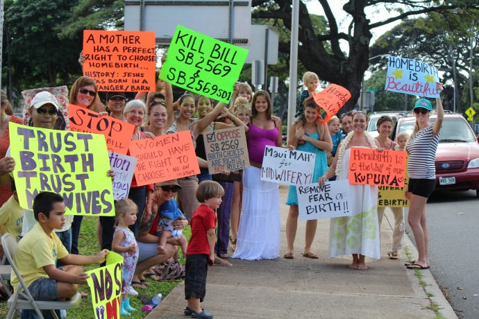 Home birth supporters on Maui carry signs in opposition to a bill before the Senate that seeks to establish licensing requirements and other restrictions on the practice. The demonstration was held on the lawn fronting the state building in Wailuku. Photo by Wendy Osher.