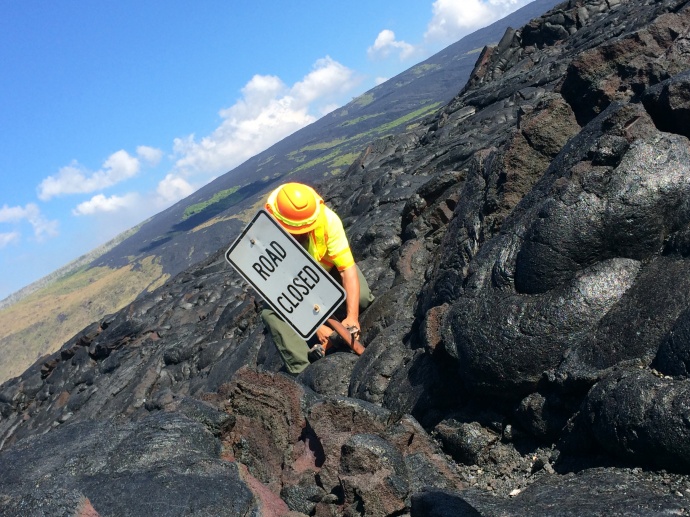 Work began today in Hawaii Volcanoes National Park on the emergency access route between the park and lower Puna on the historic Chain of Craters Road-Kalapana road alignment. Park staff removed the iconic "Road Closed" sign before the first bulldozer rolled onto the lava-covered roadway. Photo courtesy of the National Park Service.