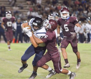 Baldwin's Joshua Yoruw (6) wrestles down Kamehameha Maui receiver Maika'ike English (13) during second-half action Saturday. Photo by Rodney S. Yap.