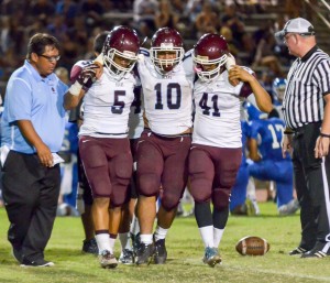 Baldwin's Chazzaniel Sa'u (10) is helped off the field by teammates Kawena Alo-Kaonohi (5) and Chris Bacos (41) and head coach Pohai Lee looks on. Rodney S. Yap.