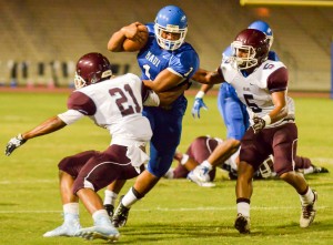 Maui High running back Soane Vaohea (1) tries to get in between defenders La'akea Kahoohanohano-Davis (21) and Kawena Alo-Kaonohi (5). Photo by Rodney S. Yap.