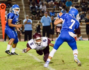 Baldwin's Kawena Alo-Kaonohi (5) lunges at the feet of Maui High quarterback Austin Hoe (7). Photo by Rodney S. Yap.