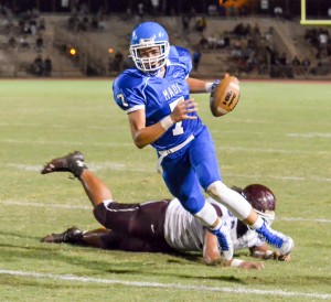 Maui High quarterback Austin Hoe (7) decides to keep the ball and avoids a Baldwin defender. Photo by Rodney S. Yap.