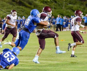 Maui High's Mykah Bailey (8) wrestles with Baldwin's La'akea Kahoohanohano-Davis while covering a kick off Friday. Photo by Rodney S. Yap.