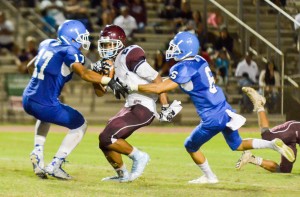 Maui High's Feleti Afemui (17) and Nathan Vierra (6) close in on Baldwin's La'akea Kahoohanohano-Davis. Photo by Rodney S. Yap.