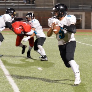 King Kekaulike quarterback Cameron Russell rolls to his left in search of a receiver. Photo by Rodney S. Yap.