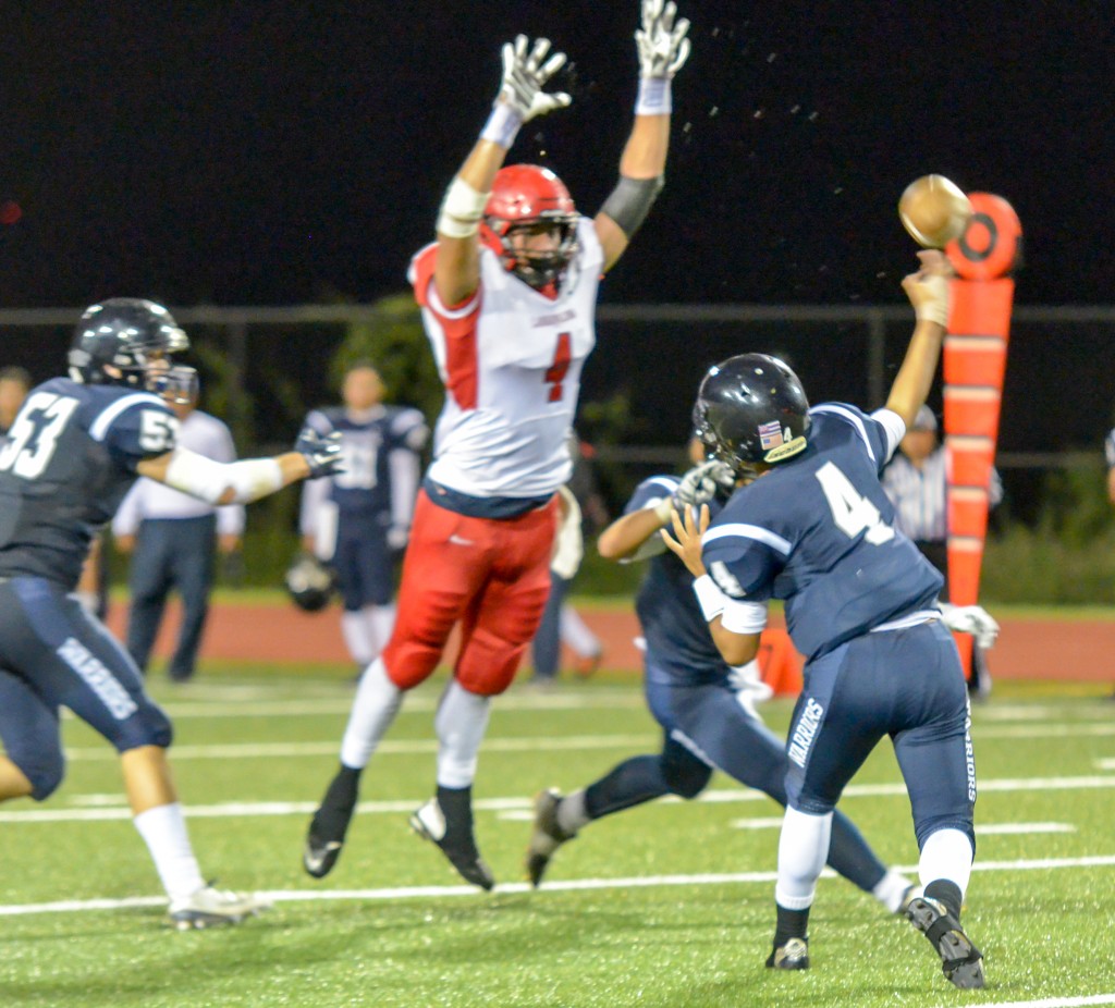 Pair of 4 do battle as Kamehameha Maui quarterback Kainoa Sanchez throws this ball around the block attempt of Lahainaluna defensive end Nau Filiai. Photo by Rodney S. Yap.