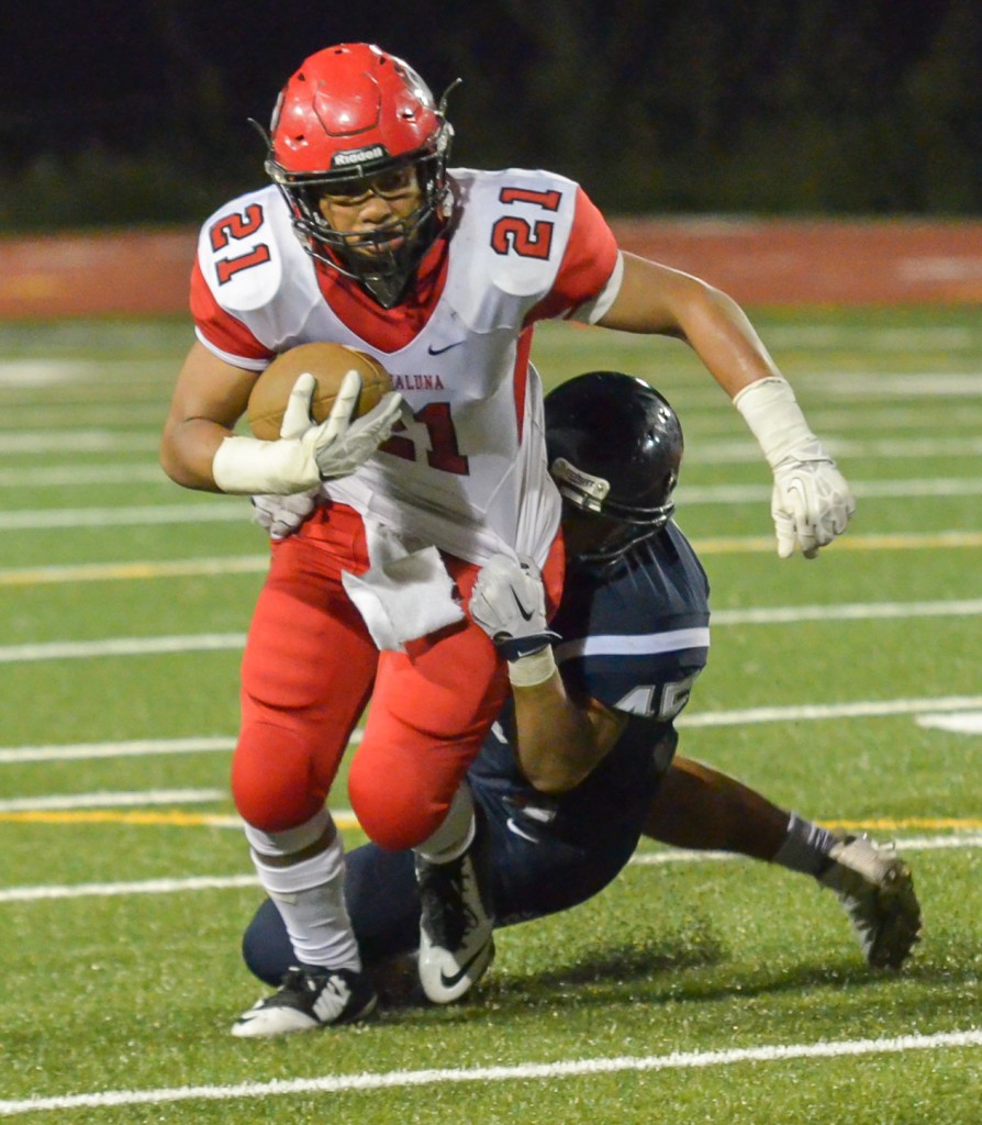 Lahainaluna's Donovan Defang (21) drags a Kamehameha Maui defender. Photo by Rodney S. Yap.