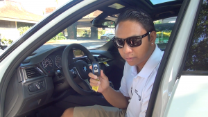 Brad Aceret, BMW of Honolulu "Product Knowledge Genius" educates drivers during the BMW Golf Challenge. Photo by Kiaora Bohlool.