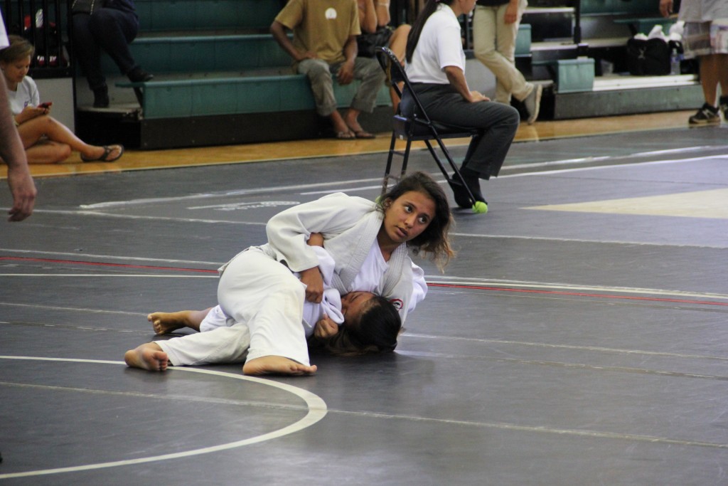 Hiialoa Palakiko of Makawao Hongwanji keeps an eye on the clock as she pins Kara Yoshiyama of Hilo Hongwanji. Palakiko won the match by ippon. Photo credit: Cy Yoshizu