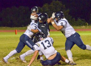 King Kekaulike's Damon Madera finds the going tough against Kamehameha Maui's defense, led by Mike Kahula (8) and Maika'ike English (13). Photo by Rodney S. Yap.