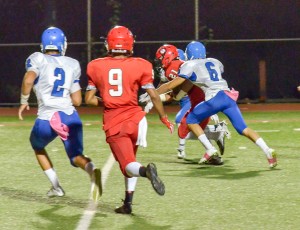 Lahainaluna junior Donovan Defang weaves his way into the end zone from 16 yards out for the go-ahead touchdown as Maui High's Nathan Vierra (6) tries to bring him down. Photo by Rodney S. Yap.