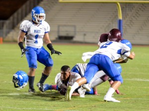 Baldwin quarterback Chayce Akaka is sandwiched between Maui High's Kahoku Kealoha (9) and Alanai Malafu (2) trying to run wide. Kealoha loses his helmet on the play. Photo by Rodney S. Yap.