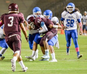 Maui High defenders converge on Baldwin's La'akea Kahoohanohano-Davis (21) after he makes a catch in the open field. Photo by Rodney S. Yap.