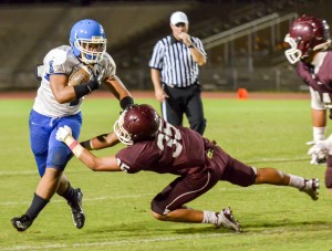 Maui High's Soane Vaohea (1) stiff arms Baldwin's Nainoa Keahi (35) during second-half action Saturday. Photo by Rodney S. Yap.