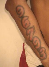 Shaun M. Dennis has the following tattoos: “Gangster holding a gun” on his right chest and “96793” on his right forearm.