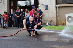 Trucker Dukes shooting water with his dad, firefighter Joshua Dukes outside of the Kahului Fire Station. Photo by Wendy Osher.