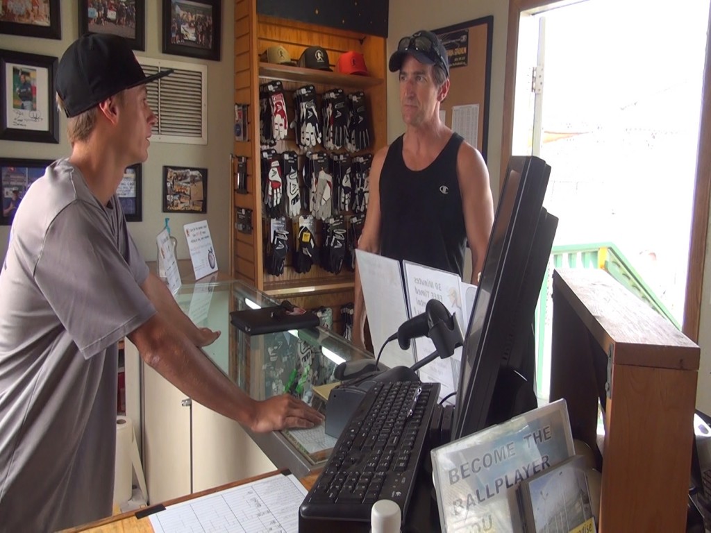 Hitter's Paradise employee Jack Klingman and customer Ty Roberts at the cash register, which the owner says was found on the ground after the theft. Photo by Kiaora Bohlool.