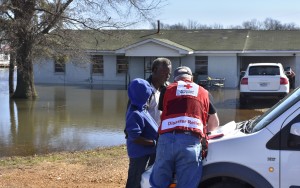 March 13, 2016. Robinsonville, Mississippi. American Red Cross client assistance teams canvassed areas of North Mississippi (Tunica County) that were affected by floodwaters. Paul Strickland and his son Paul Strickland, Jr. share their ordeal and complete paperwork with Red Cross caseworker Mike Peterson in front of his Robinsonville, Mississippi, home now surrounded by floodwaters. Photo by Bob Wallace/American Red Cross