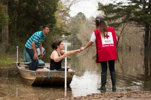 Wednesday March 16, 2016. McClain, Mississippi. Suzy Cooley and Aaron Cooley brave the flood waters on a fishing boat in McClain, MS. Red Cross volunteer, Sarah Basel, notifies them of a nearby Red Cross Point of Contact. Photo by Shannon Toombs/ American Red Cross