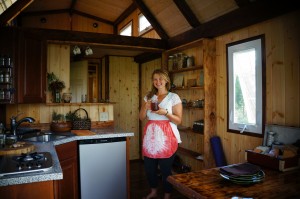 Island Tiny Homes, Jen Chalupsky in the kitchen. Photo credit: Kailea Sonrisa, www.harnessyourbreath.com