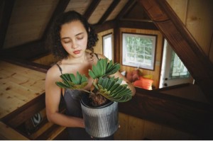 Island Tiny Homes, Viva Wittman in the loft bedroom space. Photo credit: Kailea Sonrisa, www.harnessyourbreath.com