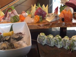Sashimi platter, behind Kumumoto oysters and a jalapeño sushi roll. Photo by Kiaora Bohlool.