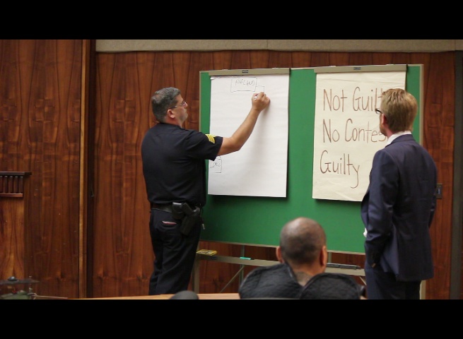 Defense attorney Samuel MacRoberts (right) asks Maui Police Sergeant Alan Brown (left) to draw a diagram of the Foodland parking lot where the police pursuit began.