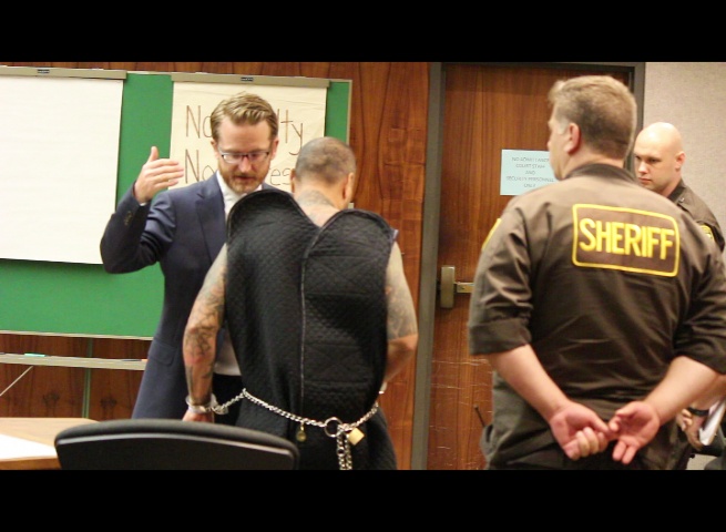 Defense attorney Samuel MacRoberts speaks with his client, defendant Stephen Schmidt.