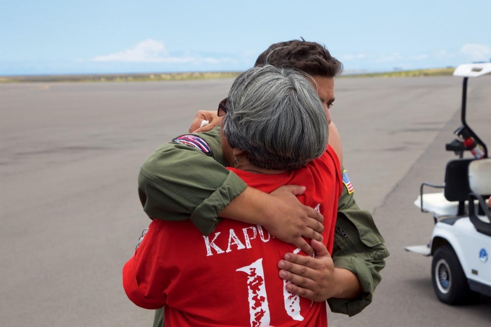 The mother of Sidney Uemoto hugs Coast Guard crews following her daughter's rescue nine miles off Kona, Hawaii, July 15, 2016. Uemoto and David McMahon were both rescued by a Coast Guard MH-65 Dolphin helicopter crew following an expansive joint search by Navy, Royal New Zealand air force, U.S. Air Force and Coast Guard crews. (U.S. Coast Guard photo by Lt. Cmdr. Kevin Cooper/Released)