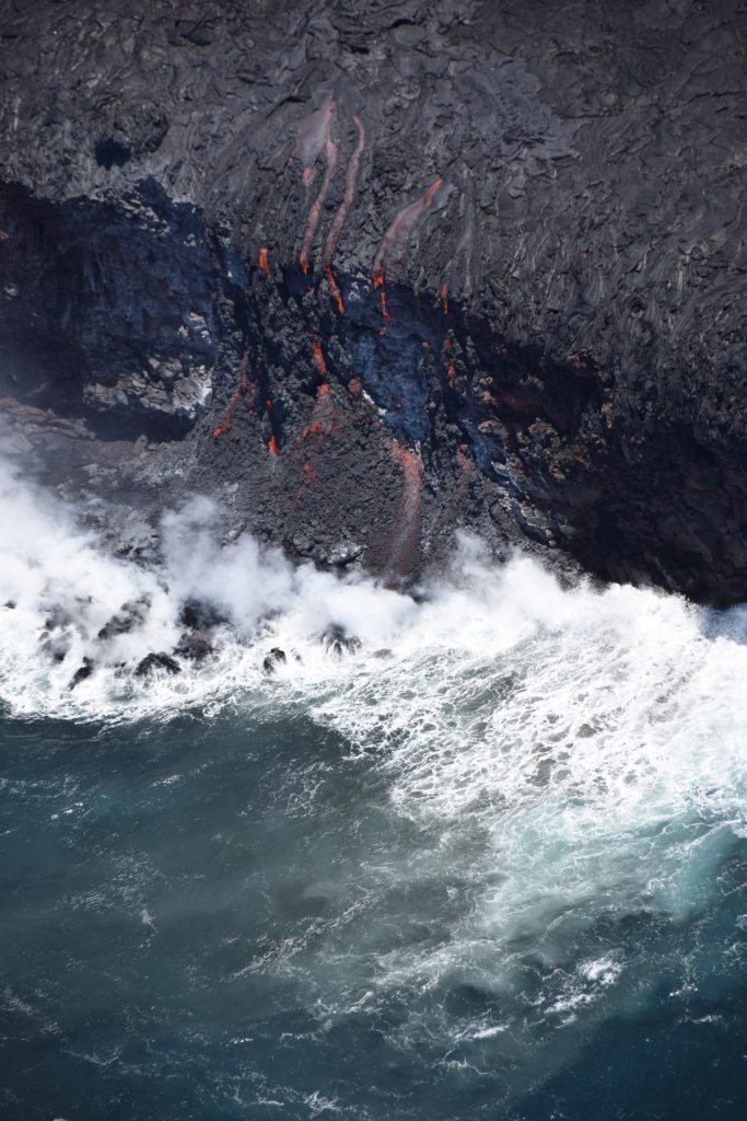 A close-up view of the ocean entry with multiple small fingers of lava spilling over the cliff. Photo credit: USGS/Hawaiian Volcano Observatory.
