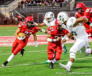 Lahainaluna's Joshua Tihada runs behind the lead block of Elijah Ragudo (24) against Kapaa Saturday at Lahaina's Sue Cooley Stadium. Photo by Rodney S. Yap.