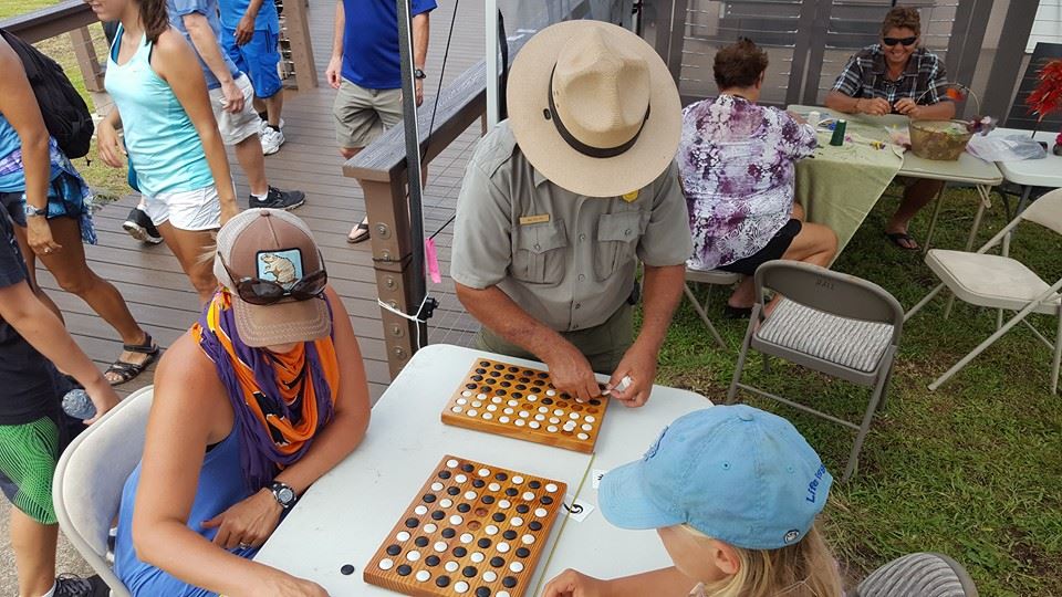 Ranger Walter shows visitors how to play konane. Photo courtesy Haleakalā National Park.