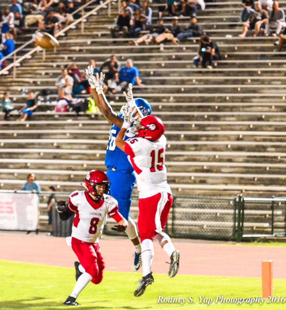 Maui High wide receiver LJ Lindsey grabs this pass from Kainalu Tancayo against Lahainaluna's double coverage for the Sabers' lone touchdown Saturday. Photo by Rodney S. Yap.