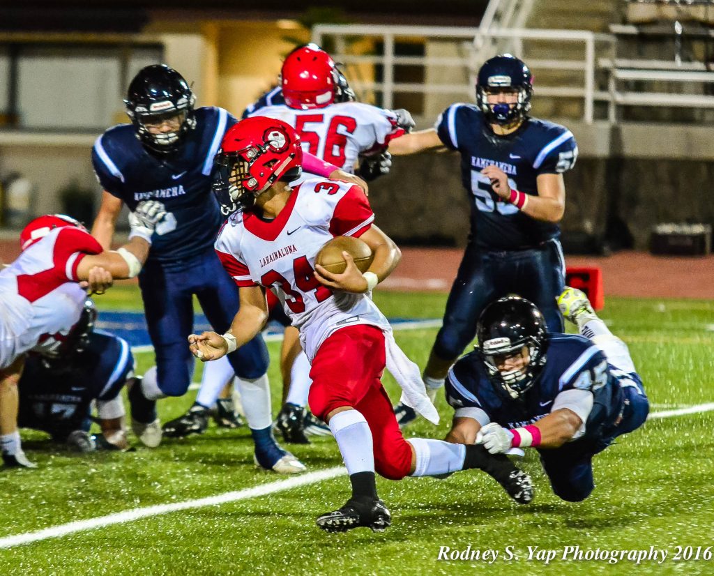 Lahainaluna's Radon Sinenci (34) avoids the outstretched arms of KS-Maui linebacker Kupono Duarte en route to scoring a touchdown. Photo by Rodney S. Yap.