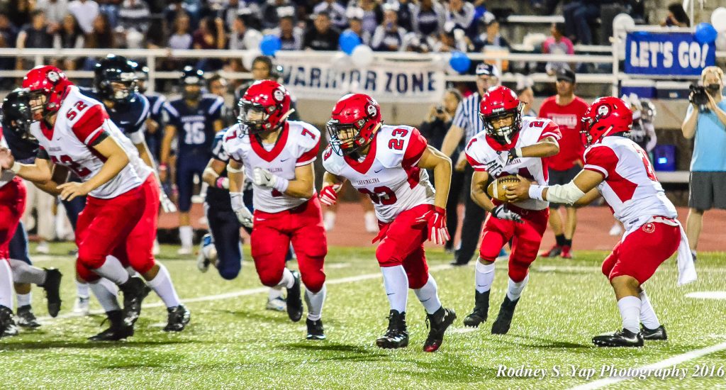 Lahainaluna's Eliajah Rajudo takes the hand off from Donavan Defang in the Wildcat offense and follows blockers Dean Miyamoto (23) and Justice Tihada (7) Saturday at Kamehameha Maui. Photo by Rodney S. Yap