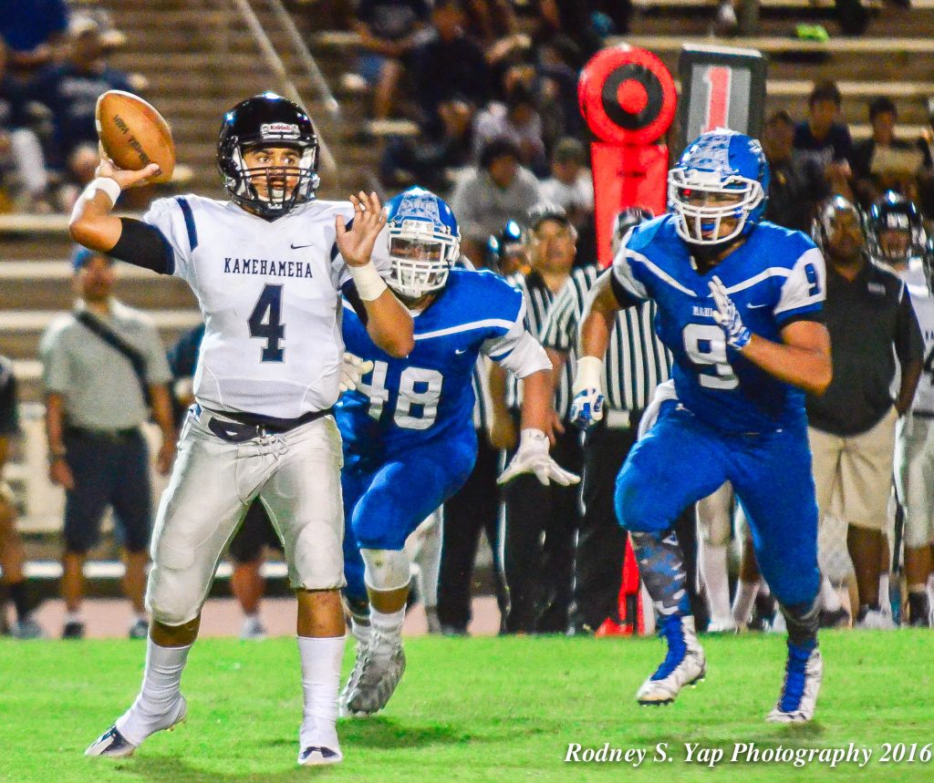 Kamehameha Maui quarterback Kainoa Sanchez hurries to getnridmof this ball as Maui High's Kahoku Kealoha (9) rushes from the backside. Photo by Rodney S. Yap.