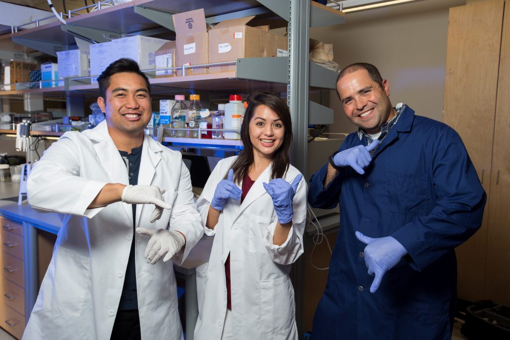Dr. Kauwe (pictured on right) with two of his students. Photo credit: Mark A. Philbrick/BYU Photo. Through the efforts of Molokai High School alumnus and BYU Associate Professor John S. K. Kauwe, Ph.D., together with a $20,000 educational grant from the philanthropic Monsanto Fund, Molokai High students will enhance their education in genetics and the scientific research process, aided by new science lab equipment at the school and summer internships at BYU.