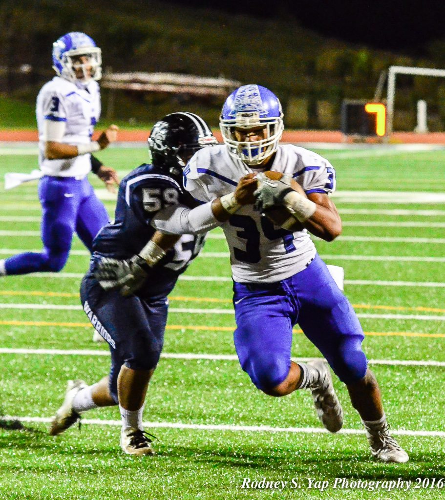 Maui high School's Hanisi Lotulelei (34) shakes a would-be Warrior tackler en route to scoring his third rushing touchdown of the game Friday at Kamehameha Maui. Photo by Rodney S. Yap.