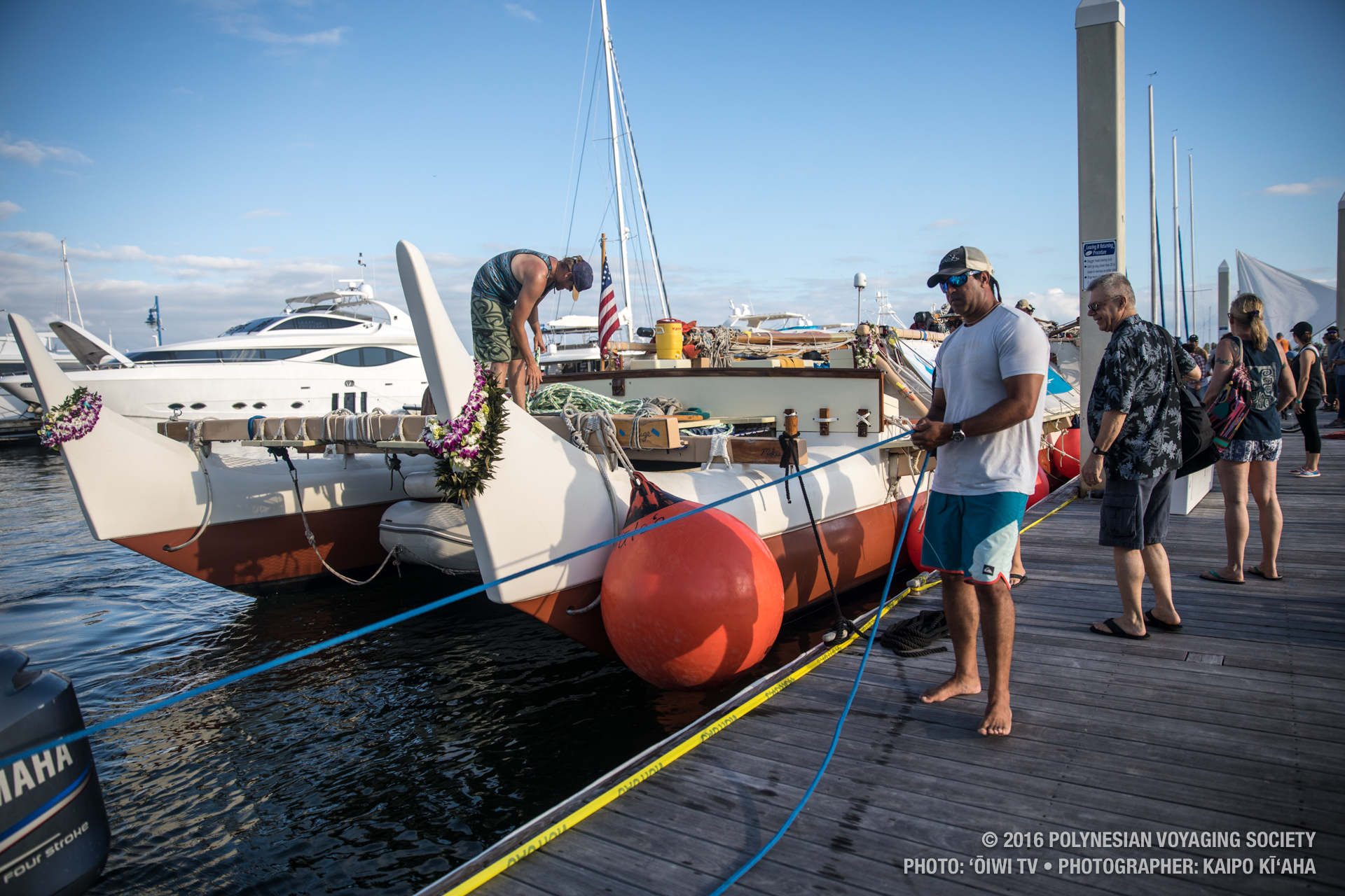 Kawika Crivello pulling in the stern line of Julie's Cat with Hōkūleʻa behind. PC: ʻŌiwi TV/Kaipo Kīʻaha/2016 Polynesian Voyaging Society.