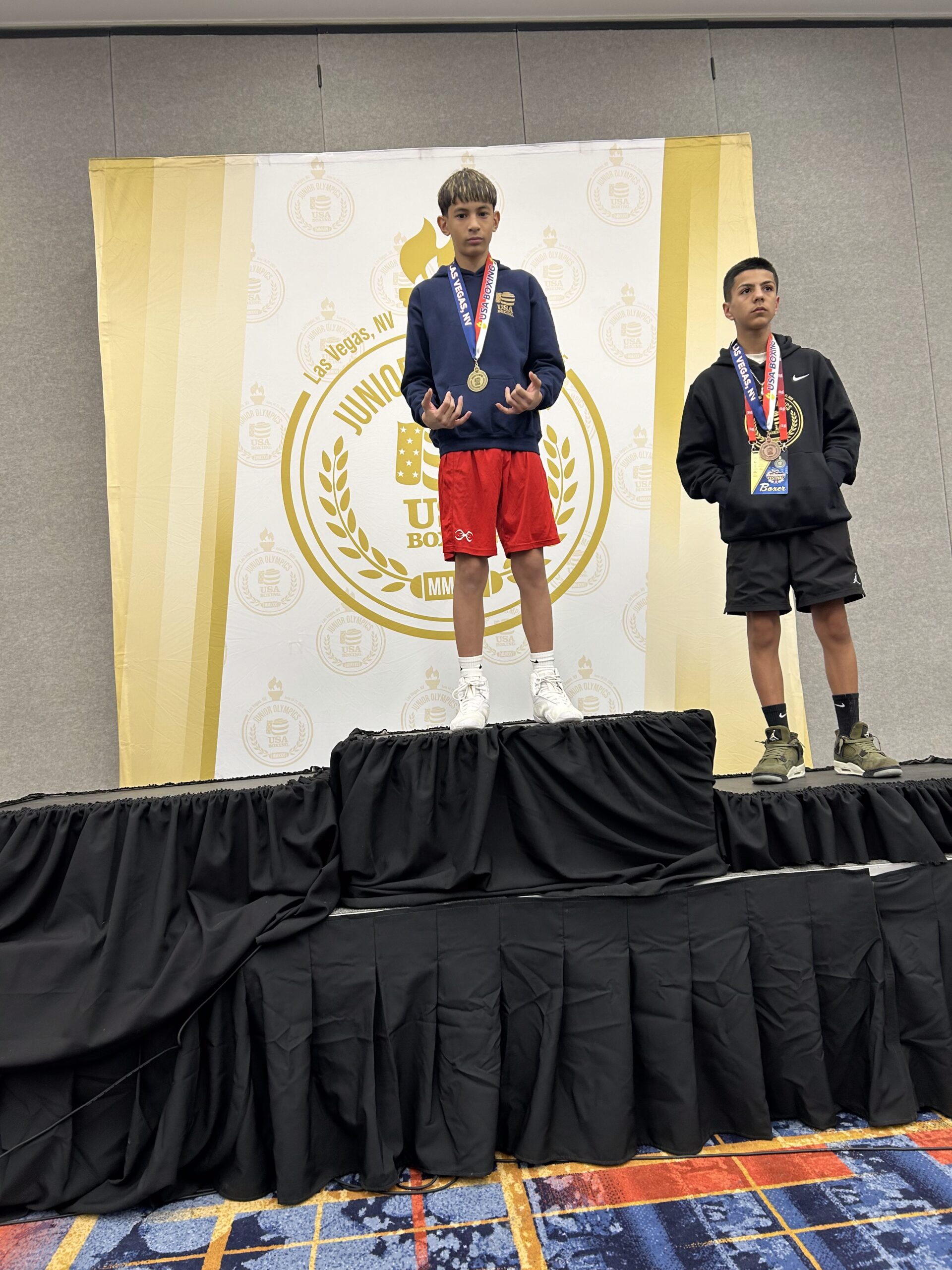 Micah Diaz, a 13-year-old from rising eighth grader at Lokelani Intermediate School, stands atop the podium alongside second-place finisher Anthony Aceves, Bakersfield, Calif., after Diaz won the USA Boxing Junior Olympics 90-pound intermediate division title in Las Vegas on June 20. Tiana Diaz photo