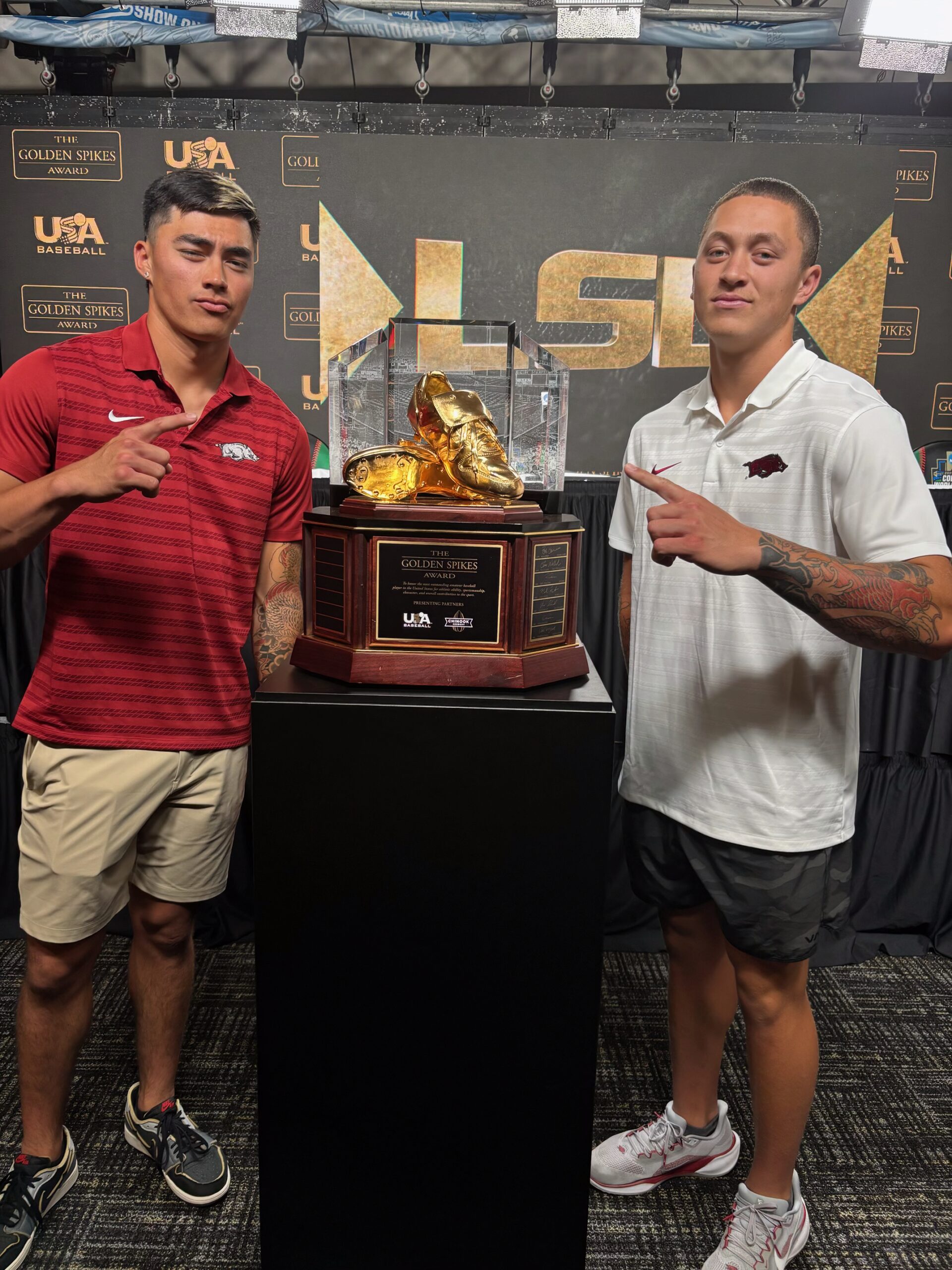 Brothers Wehiwa Aloy (left) and Kuhio Aloy stand next to the Golden Spikes Award that Wehiwa Aloy, a 2022 Baldwin High School graduate, won on Saturday as a member of the University of Arkansas baseball team. The award goes to the best amateur baseball player in the country. Courtesy photo