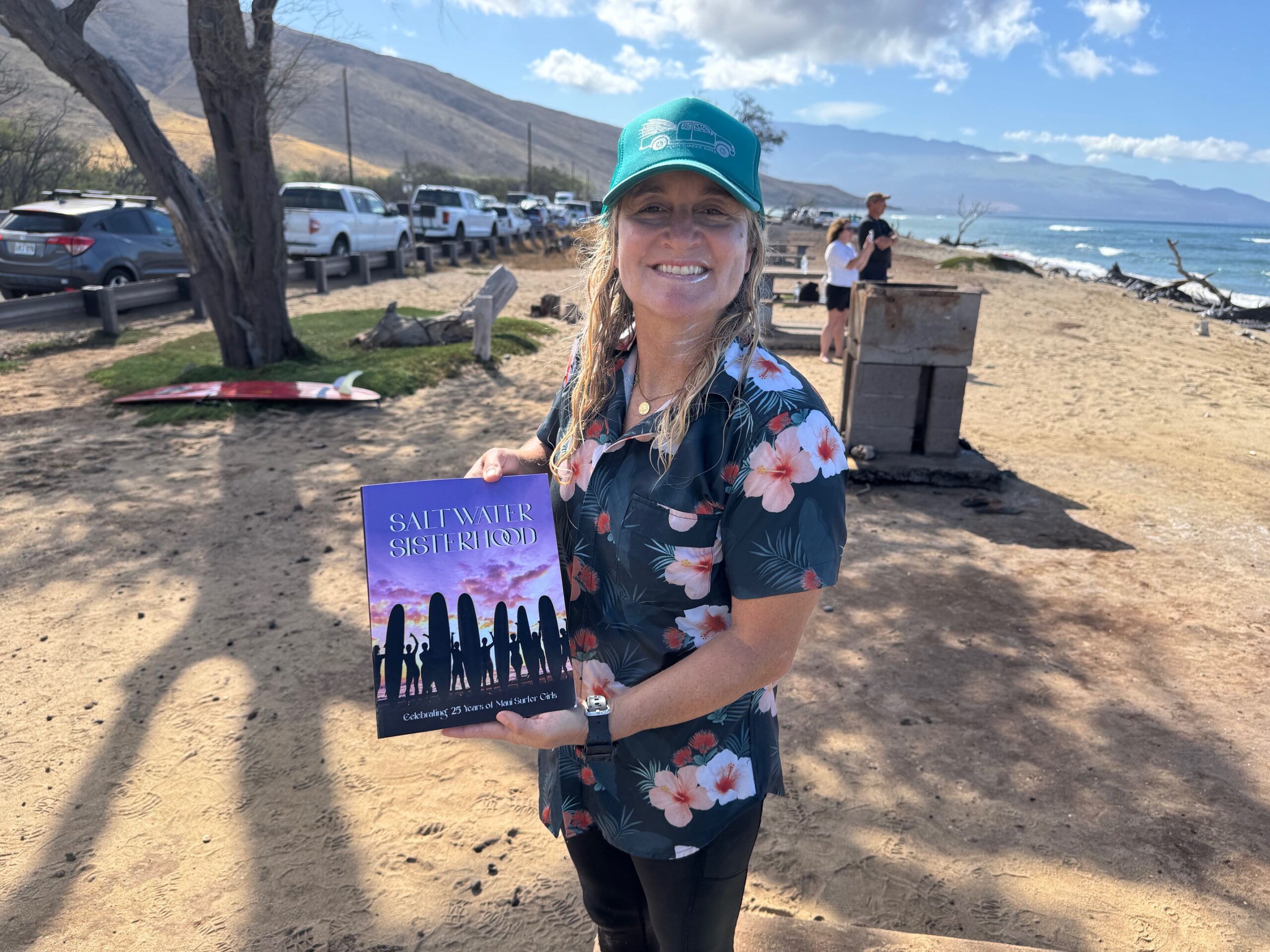 Maui Surfer Girls founder Dustin Tester shows off her book "Saltwater Sisterhood" on June 20 at Ukumehame Beach Park. HJI / ROB COLLIAS photo